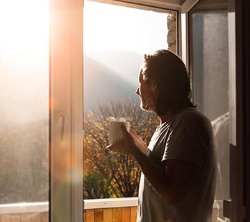 man drinking coffee admiring view of mountains